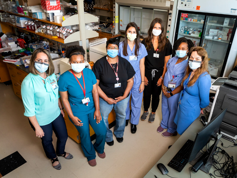 Group of researchers pose for a picture in a lab.